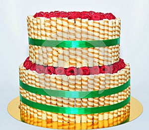 Two tier cake decorated with finetti sticks and fresh raspberry