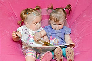 Two toddlers reading together