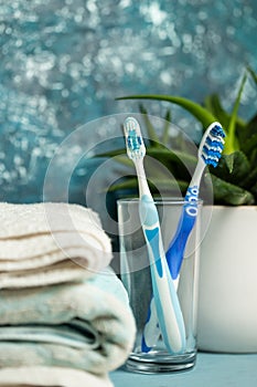 Two toothbrush in a glass on a blue background