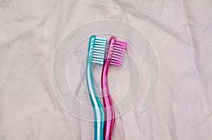 Two toothbrushes arranged like couple on bed spooning