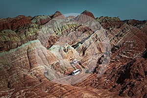 Two tour busses crossing Zhangye Danxia National Park with rainbow mountains, Gansu, China