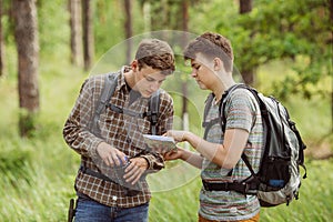 Two tourist determine the route map and compass