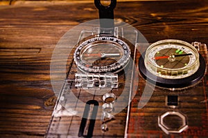 Two magnetic compasses on wooden table