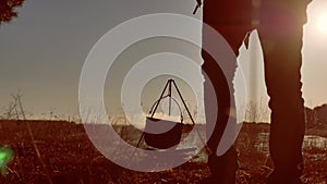 Two tourists beer are sitting by bonfire lifestyle hiking party in nature camping silhouette sunlight sunset. two men