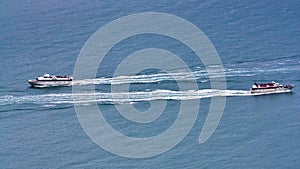 Two tourists boat cruising on the sea in opposite directions