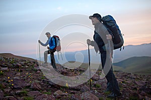 Two tourists at dawn in mountains