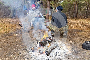 Two tourists are sitting by the big fire