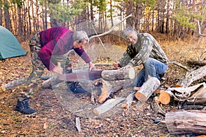 Two tourists with a two-handed saw cut a log