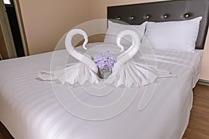 Two towel swans shaped on the bed