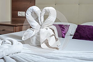 Two towel swans. Two swans made of towels forming heart shape on bed in honeymoon suite room hotel