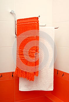 Two towels are in an orange bathroom