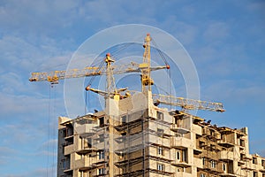 Two tower crane at a construction site in the autumn