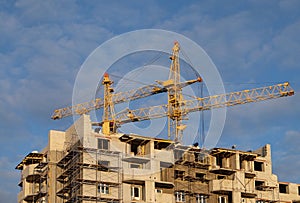 Two tower crane at a construction site in the autumn