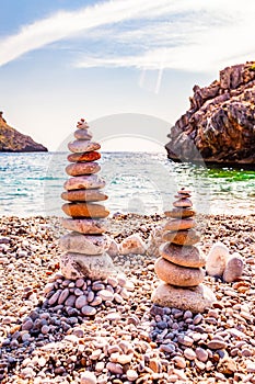 Two towers of flat stones on the beach. Stone balancing is the art discipline, or hobby in which rocks naturally balanced on top