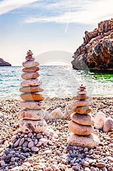 Two towers of flat stones on the beach. Stone balancing is the art discipline, or hobby in which rocks naturally balanced on top