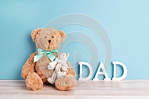 Two toy bears of dad and child on blue background. Father`s Day