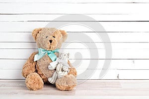 Two toy bears of parent and child on white wooden background. Pa