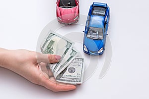 two toy cars with cash in hand.