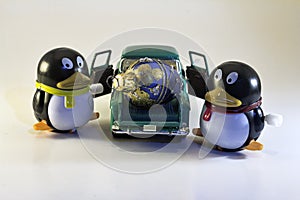 Two Toy Penguins with Holiday Ornament in Truck