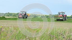 Two Tractors collecting silos aon field Close up