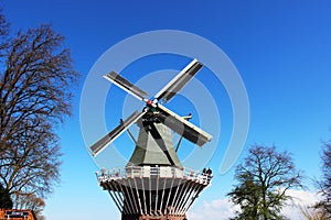 Two traditional Dutch windmills with tulips rows at spring day, Netherlands