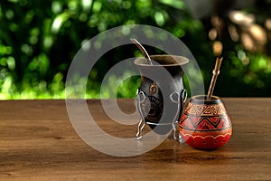 Two traditional mates made of calabash over a wooden table