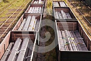 Two trains on the railroad cars which steel billets for pipes