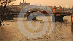 Two Trams Crossing the Legion Bridge in Prague During Sunset