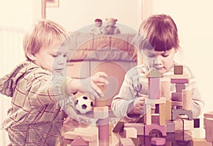 Two tranquil children playing with wooden blocks