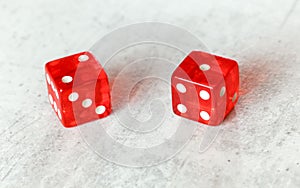 Two translucent red craps dices on white board showing Ace Deuce number 2 and 1 photo