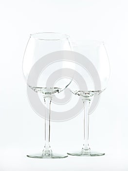 Two transparent elegant crystal glasses for cocktails and wine on a white background