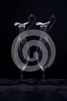 Two transparent glass vases on a black background