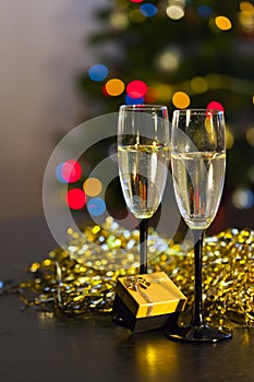 Two transparent glasses with black stems of champagne with bubbles