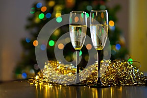 Two transparent glasses with black stems of champagne with bubbles