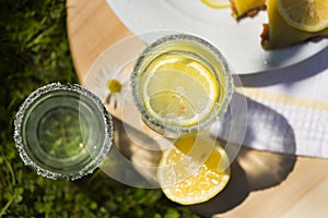 Two transparent glasses of lemonade and lemon slices