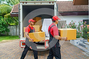 Two transport workers unloading boxes in order to move to a new house for customers
