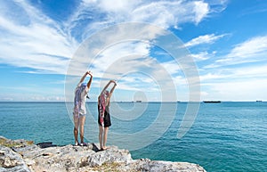 Two traveler young women seeing the beautiful beach and blue sky, so happy and relax.