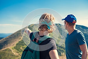 Two travelers discuss about itinerary on the top of mountain hill