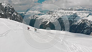Two traveling women walking upwards on the snowy mountain - Dolomites, Italy