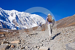 Two trekkers running on the road against Tilicho photo