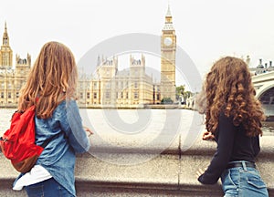 Two trendy teenage girls look at Big Ben, London