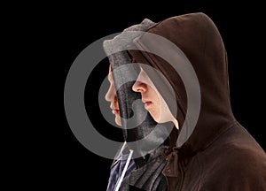 Two troubled teenage boys with black hoodie standing next to each other in profile isolated on black background - stock