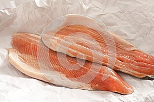 Two trout fillets displayed on paper