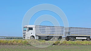 Two trucks are driving along the road next to each other. Trucks are driving along the highway