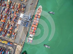 two tug boat towing cargo container in warehouse harbor at thailand .