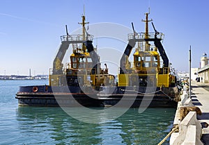 Two tugs boat stands ready to help ships in the port