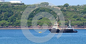 Two tugs stand sentinel to help protect the environment and vessels in the Cleddau estuary near to Pembroke Dock, Wales