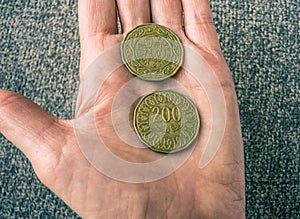 Two Tunisian coins on the woman's palm
