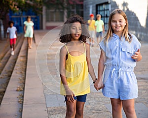 Two tween girls walking around city in summer