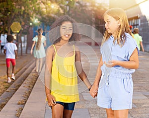 Two tween girls walking around city in summer